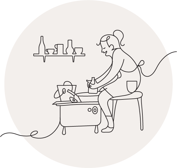 Woman seated at a pottery wheel shaping clay.